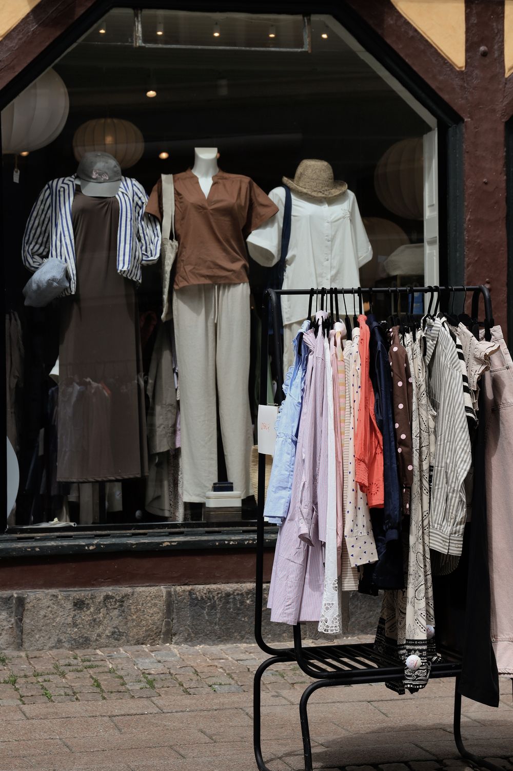 Stylish clothing display in a Helsingør boutique featuring mannequins and diverse apparel.